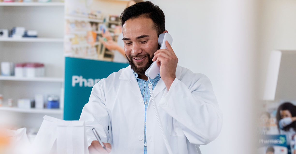A pharmacist speaking to a patient on the phone.