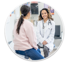 A doctor sitting across from and speaking to her patient.