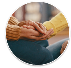 A photo of a peer mentor or support person comforting someone by holding their hands.