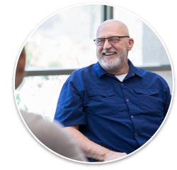 A man with glasses smiling