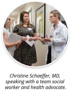 Christine Schaeffer, MD, speaking with a team social works and health advocate.